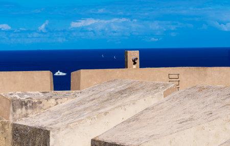 Two sailboats on the horizon and a wall.の写真素材