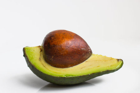 Front view of an avocado cut in half with a white background