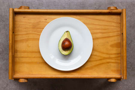 Top view of an avocado cut in half served on a wooden tableの写真素材