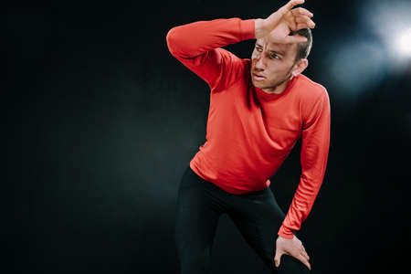 Attractive man athlete relaxing after hard workout at the gym, put his hand on the head. Sporty man wearing red sportswear. Lifestyle inspiration for sport. Motivation.の写真素材