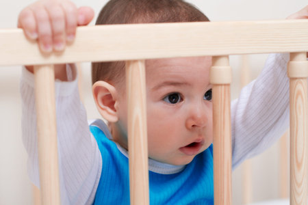 Adorable cute baby toddler in the white bed look at one side