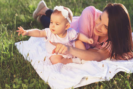 Happy mom and daughter playing at natureの写真素材