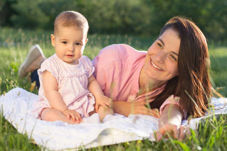 Happy mom and daughter playing at natureの写真素材
