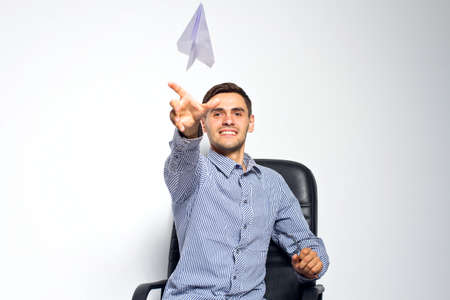 Business man throwing a paper plane on white backgroundの写真素材