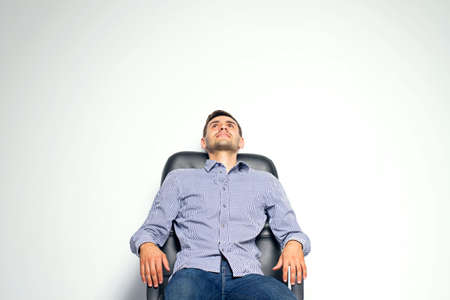 Business man sitting on chair and posing isolated on white backgroundの写真素材