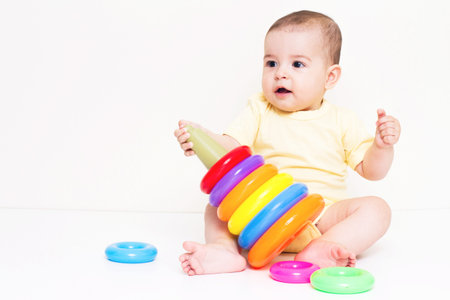 Beautiful baby playing with colorful toyの写真素材