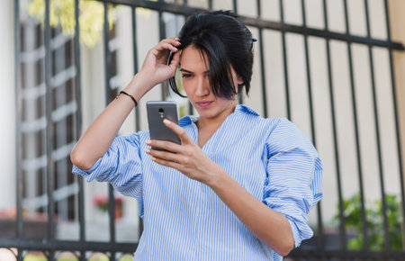 Business, lifestyle and people concept. Outdoor shot of pretty stylish Caucasian woman arrange her...