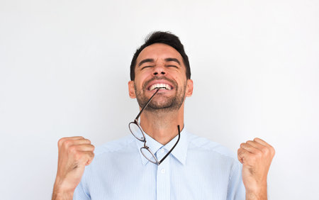Horziontal portrait of happy unshaven winner young male clenches fists and celebrates his victory,...
