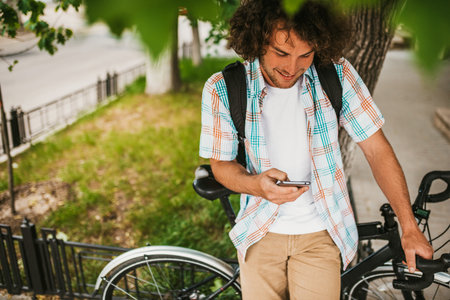 Image from above of happy young male student smiling with curly hair wearing shirt with backpack,...