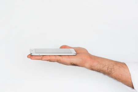 Hand of a man with mobile smart phone isolated on gray background. Presentation of a innovation...