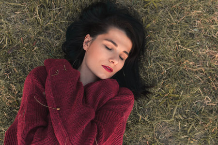 Top view of cheerful close up portrait of a beautiful young Caucasian woman smiling and closed eyes,...
