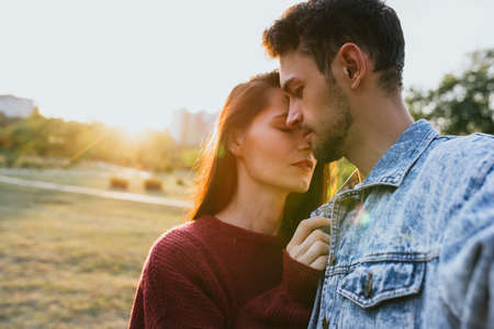 Fashion romantic traveling couple making selfie on park background, attractive sunlight, carefree mood. Caucasian man and woman embracing together at date day on naure backgroud. Lifestyle concept.の写真素材