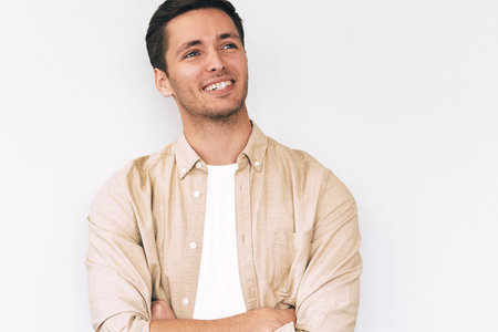 Waist up image of handsome happy young man entrepreneur smiling broadly, wearing white t-shirt and...