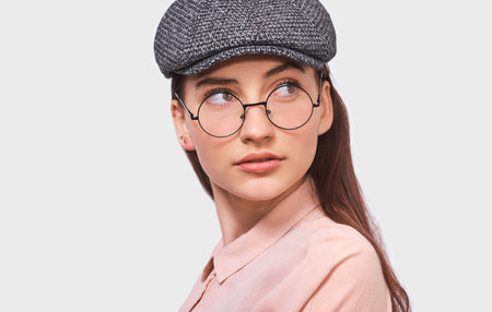 Close up portrait of beautiful young woman wears transparent spectacles, casual pink shirt and...