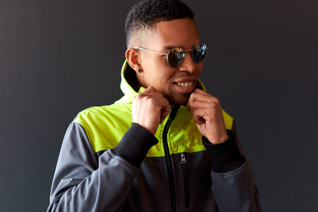 Portrait of stylish freelancer African American man smiling broaldy and looking through mirror...