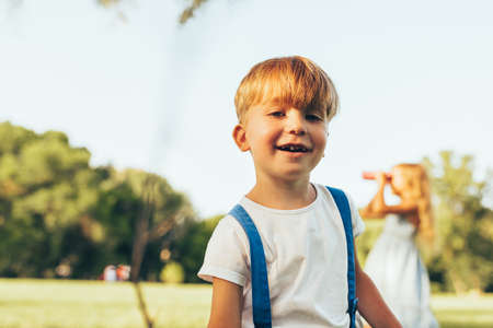 Joyful little boy playing in summer day in park. Happy child playing outdoors games on green grass. Childhood conceptの写真素材