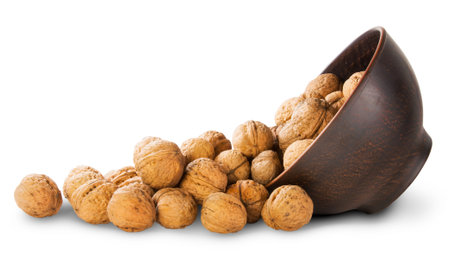 Walnuts Spill Out Of A Clay Bowl Isolated On White Background