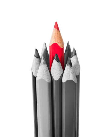 Red pencil surrounded by black and white pencils isolated on white backgroundの写真素材