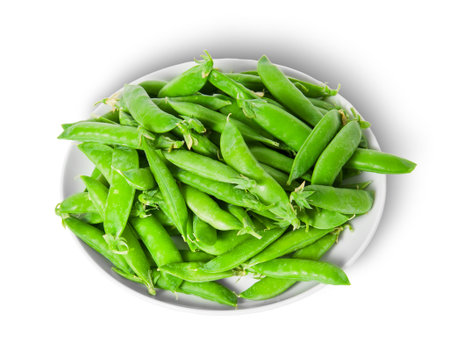 Small pile of green peas in pods on white plate isolated on white backgroundの写真素材