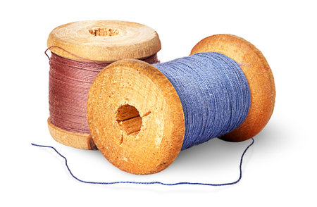 Two different colored thread on wooden spools isolated on white background