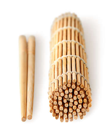 Sushi mat foldered and chopsticks near isolated on white backgroundの写真素材