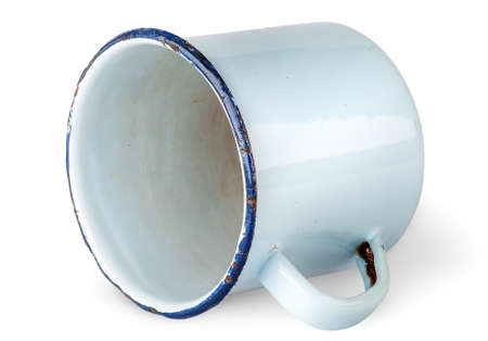 Old worn enameled mug lying isolated on white backgroundの写真素材