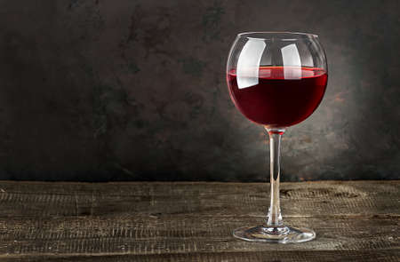 Glass of red wine on a wooden tableの写真素材