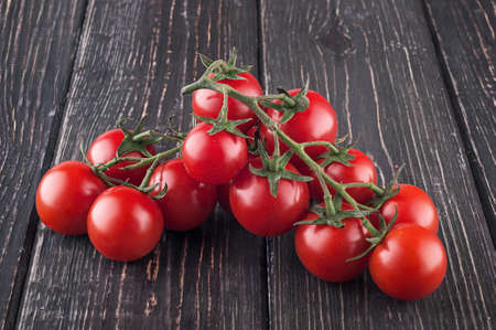 Branches cherry tomatoes on wooden tableの写真素材