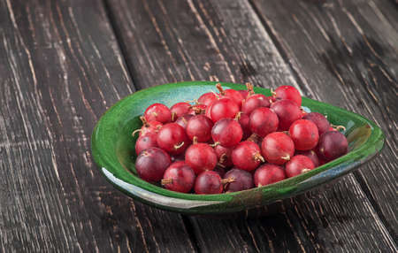 Red gooseberry in clay bowlの写真素材