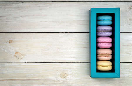 Multicolored macaroons in gift box on wooden backgroundの写真素材