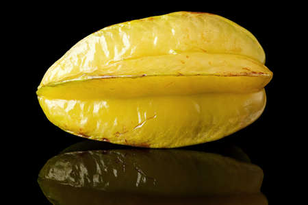 Ripe yellow carom with reflection on blackの写真素材
