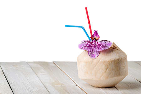 Young coconut with orchid flower on wooden table isolated on white backgroundの写真素材