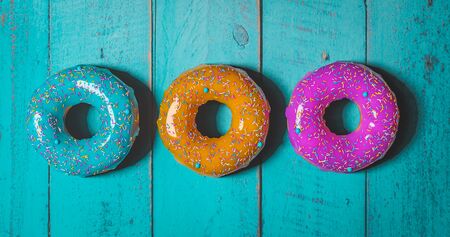 colorful donuts assorted donuts with chocolate frosted, pink glazed and sprinkles donutsの写真素材