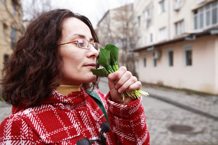 Young Girl Smelling Snowdrop In Townの写真素材