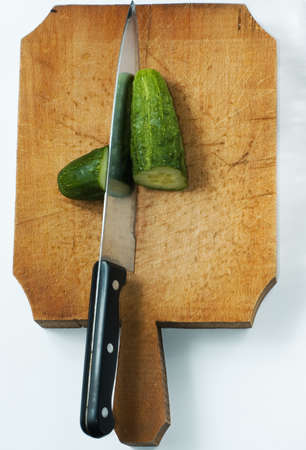 cucumber with kitchen knife on wood tableの写真素材
