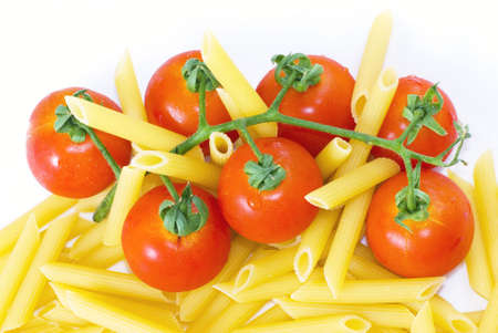 Pennette rigate and red cherry tomato on white dish with selective focusの写真素材