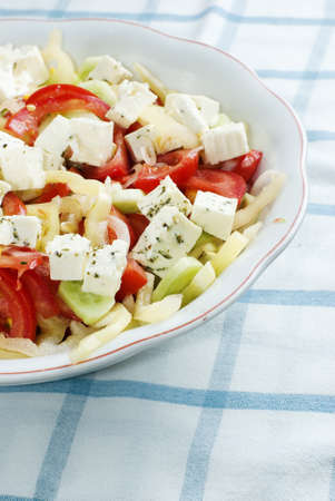Delicious bowl of greek style salad, with tomato, onions, feta cheese and cornの写真素材