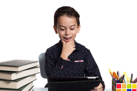 Happy student doing homework using a digital tablet.の写真素材