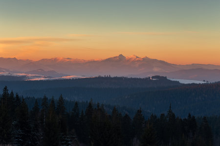 Sunset on a winter day in the mountains with colorful sky and peaks