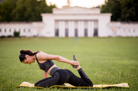 Beautiful young woman lying on a yellow mattress, pose while wearing a tight sports outfit in the...