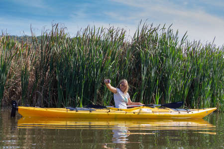 Pchelina, Bulgaria - Oct 3 2020: a woman is taking selfie while kayaking in Pchelina damのeditorial素材