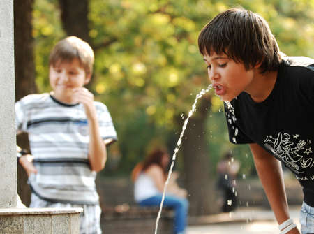 Sofia, Bulgaria - Aug 25 2012: A boy drinking from a water fountain in the city park during the hot summer days.のeditorial素材