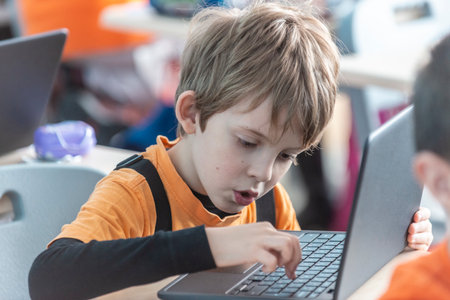 Sofia,Bulgaria- February 6, 2020: Children express emotions while learning using a laptop at schoolのeditorial素材