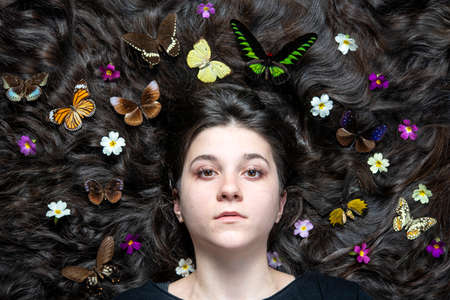 Spring girl with flowers and butterflies in the hairの写真素材