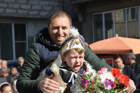 Ribnovo, Bulgaria - Apr 11 2021: Father and son riding a horse preparing for circumvention ritual...