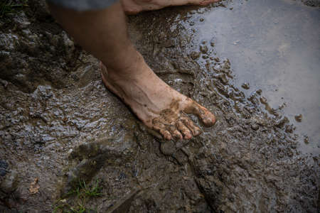 Feet in the water. People crossing muddy river in springの写真素材