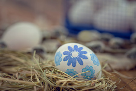 Decorated Easter eggs in nest on rustic wooden background