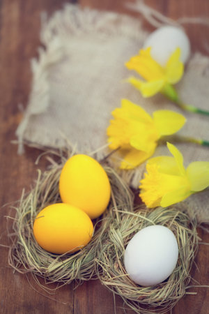 Easter eggs in nest on wooden background
