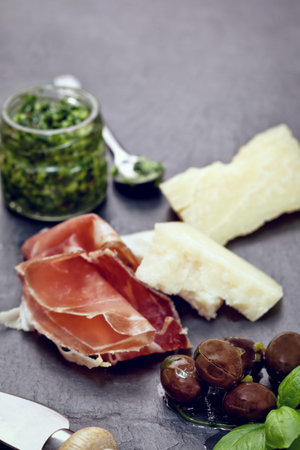 Prosciutto with pesto and Parmesan on stone tableの写真素材