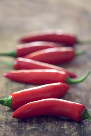 Red jalapeno peppers on wooden table  with copy space